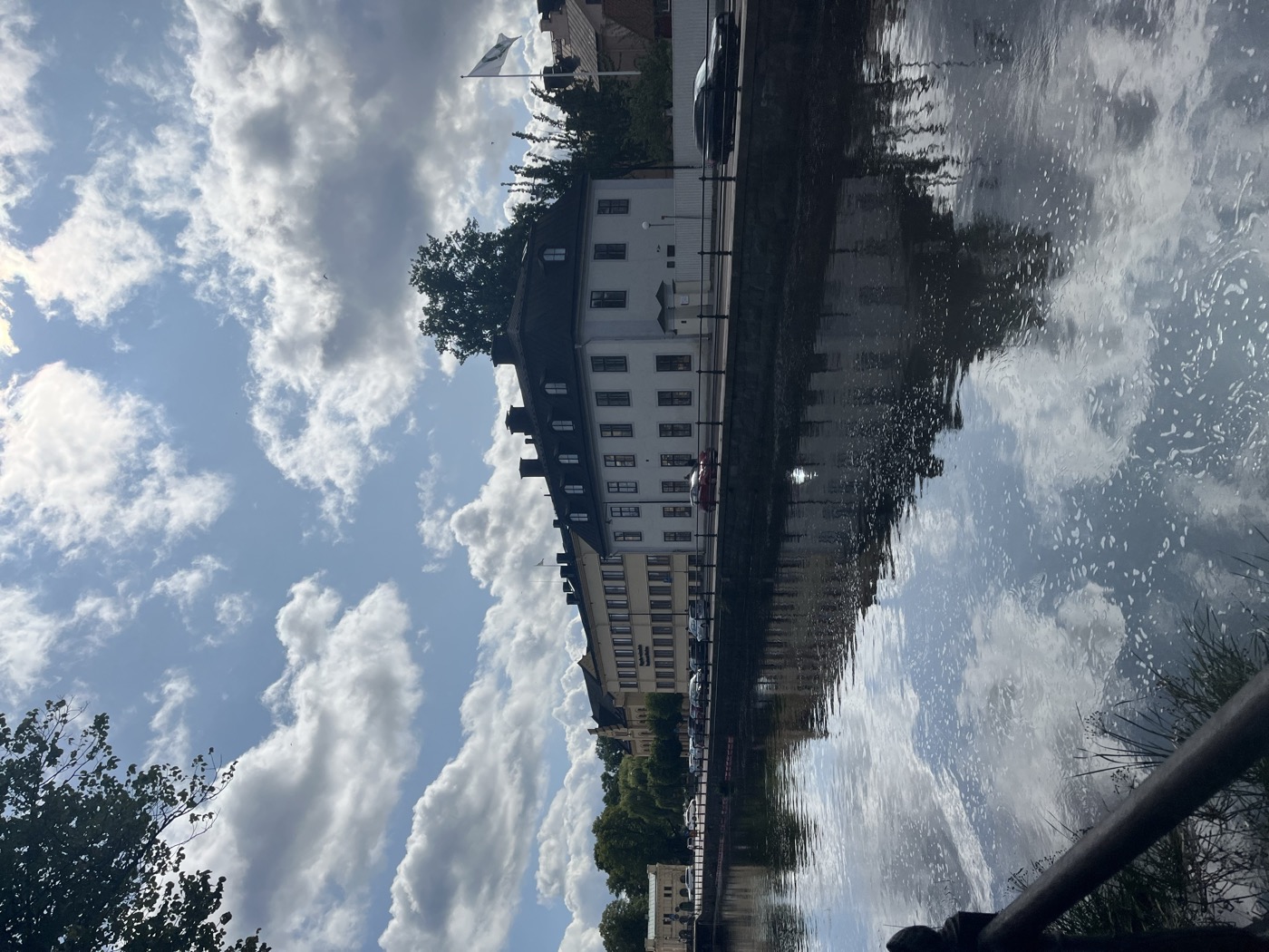Buildings reflected in a canal under a cloudy sky